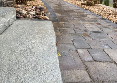 Stone steps meet brick walkway for a elegant design and rich appearance
