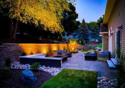 Outdoor stone patio and retaining wall create a beautiful outdoor haven for relaxation and entertainment